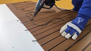 Manufacturing process of synthetic teak decking panels using heat welding